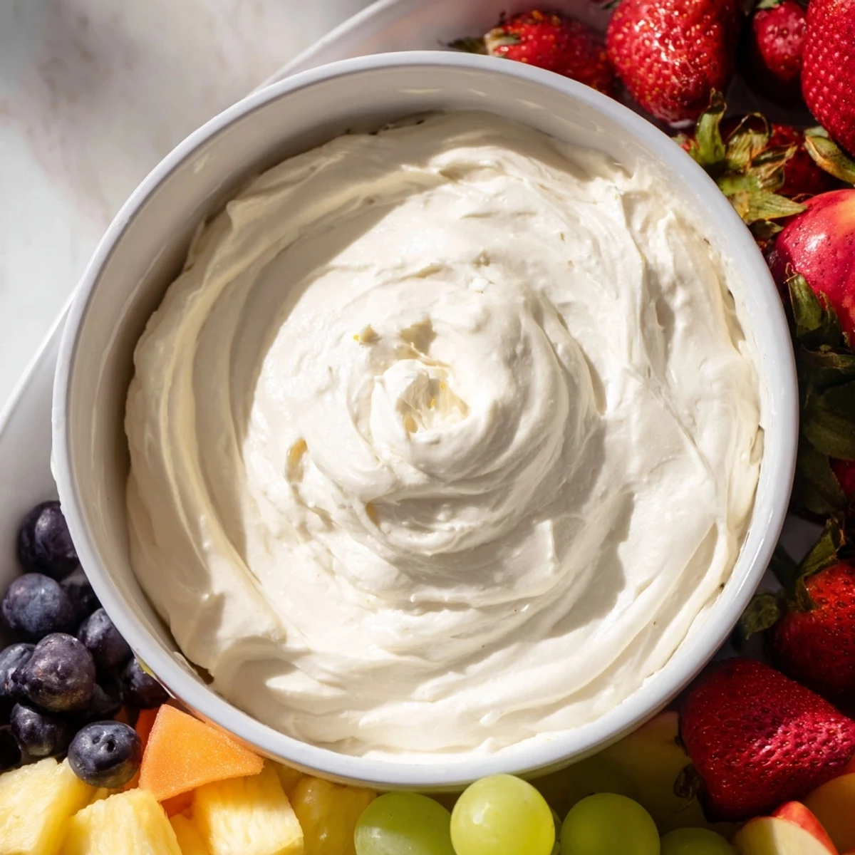 A close-up of a delightful cream cheese fruit dip, ready to be enjoyed with sweet berries.