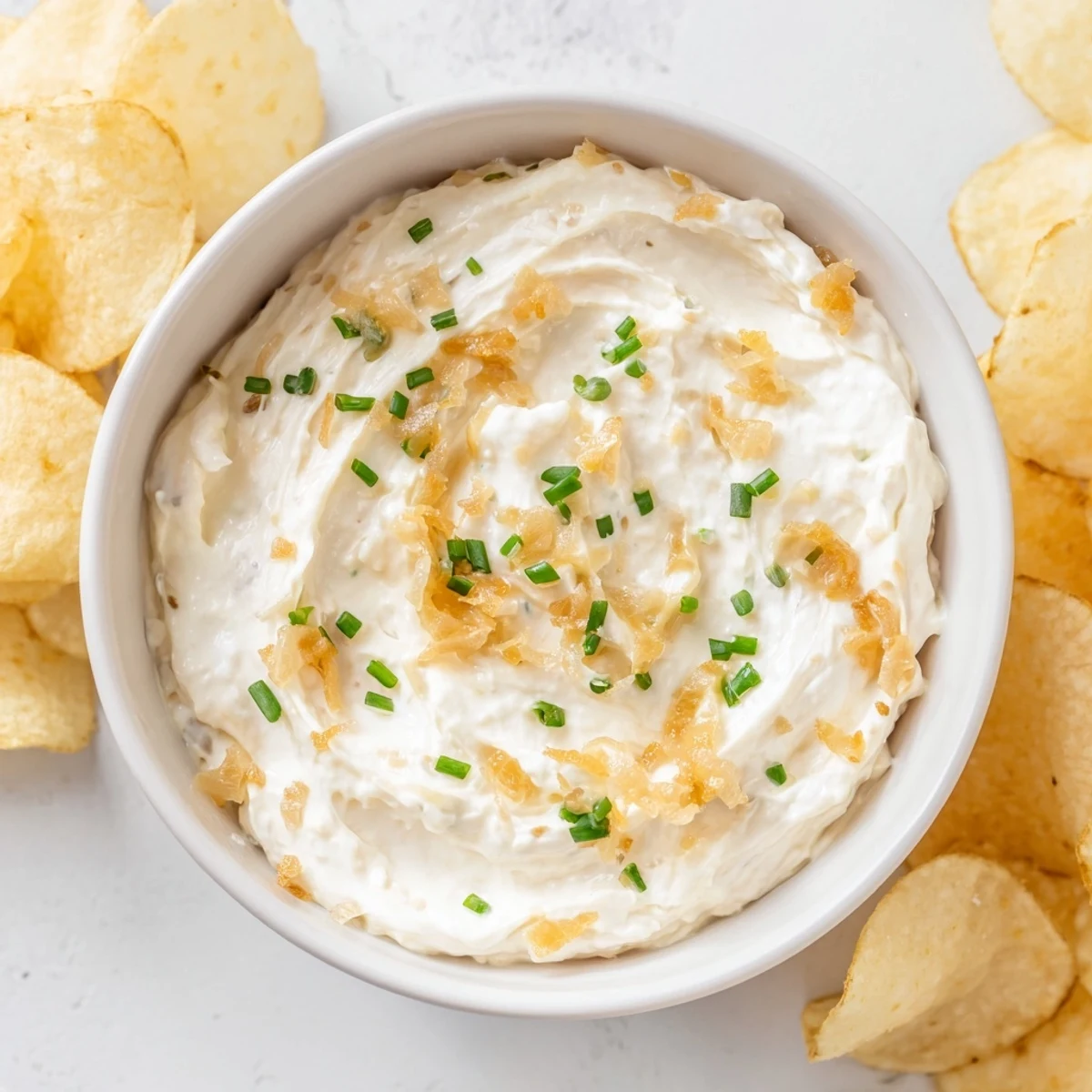 Close-up of potato chips and onion dip; the savory snack is ready and inviting guests.