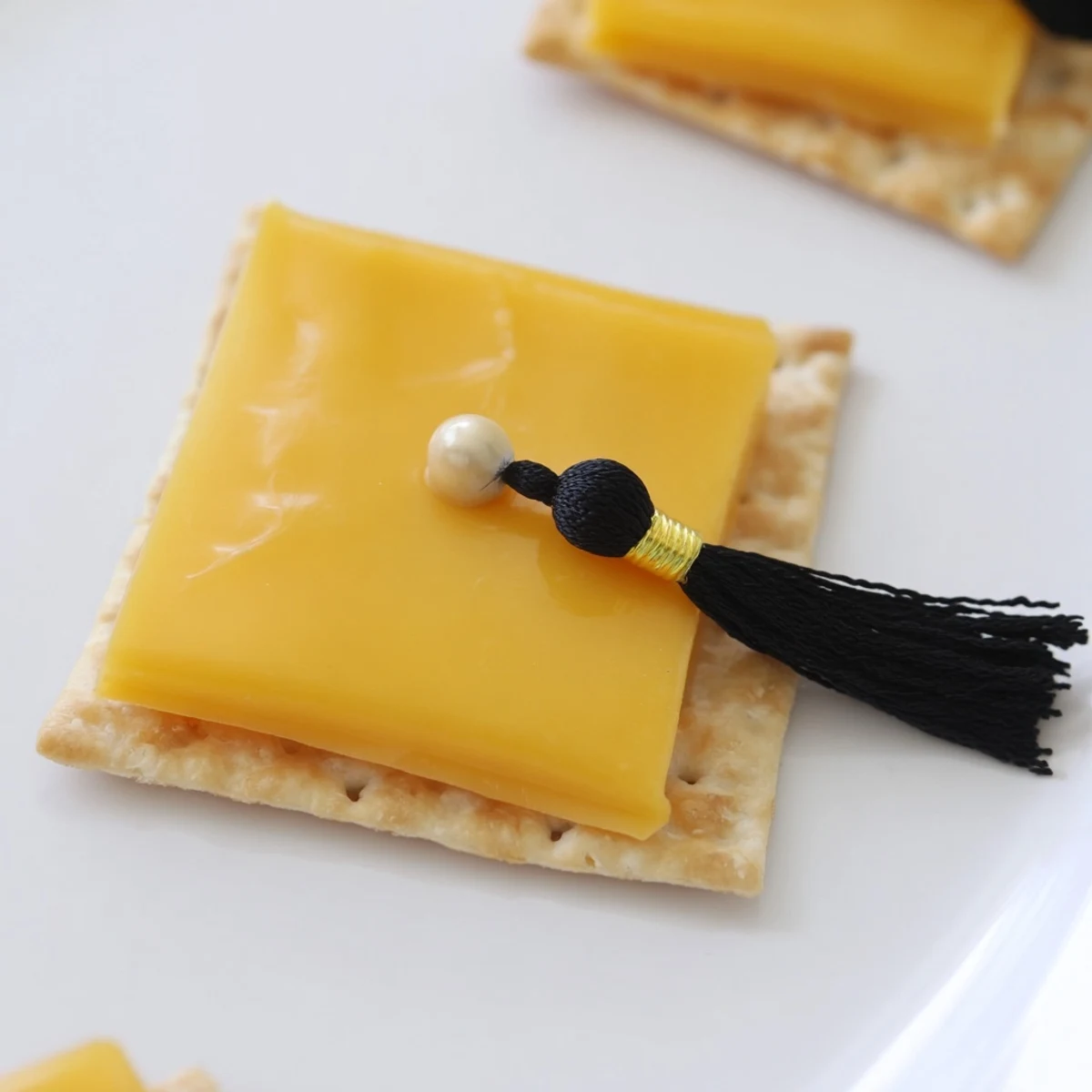 Close-up of adorable Graduation Cap Snacks, perfect party food with cheese and cracker foundations.