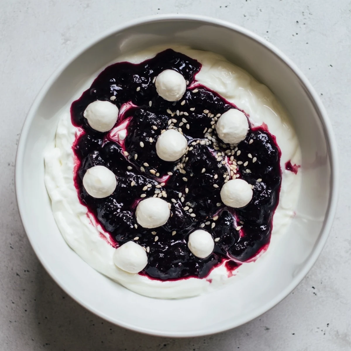 The Galaxy Spiral dessert features swirled berry jam on creamy yogurt, sprinkled with sesame seeds.