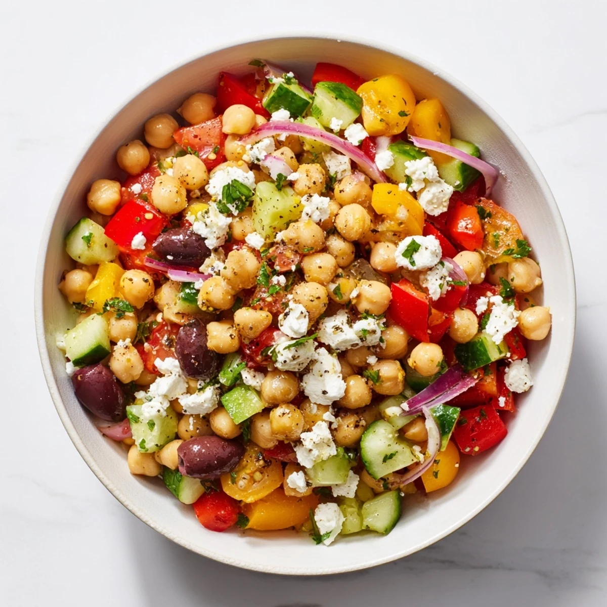 Bright, healthy Mediterranean Chickpea and Feta Bowl boasting chickpeas, veggies, and crumbles of feta cheese.