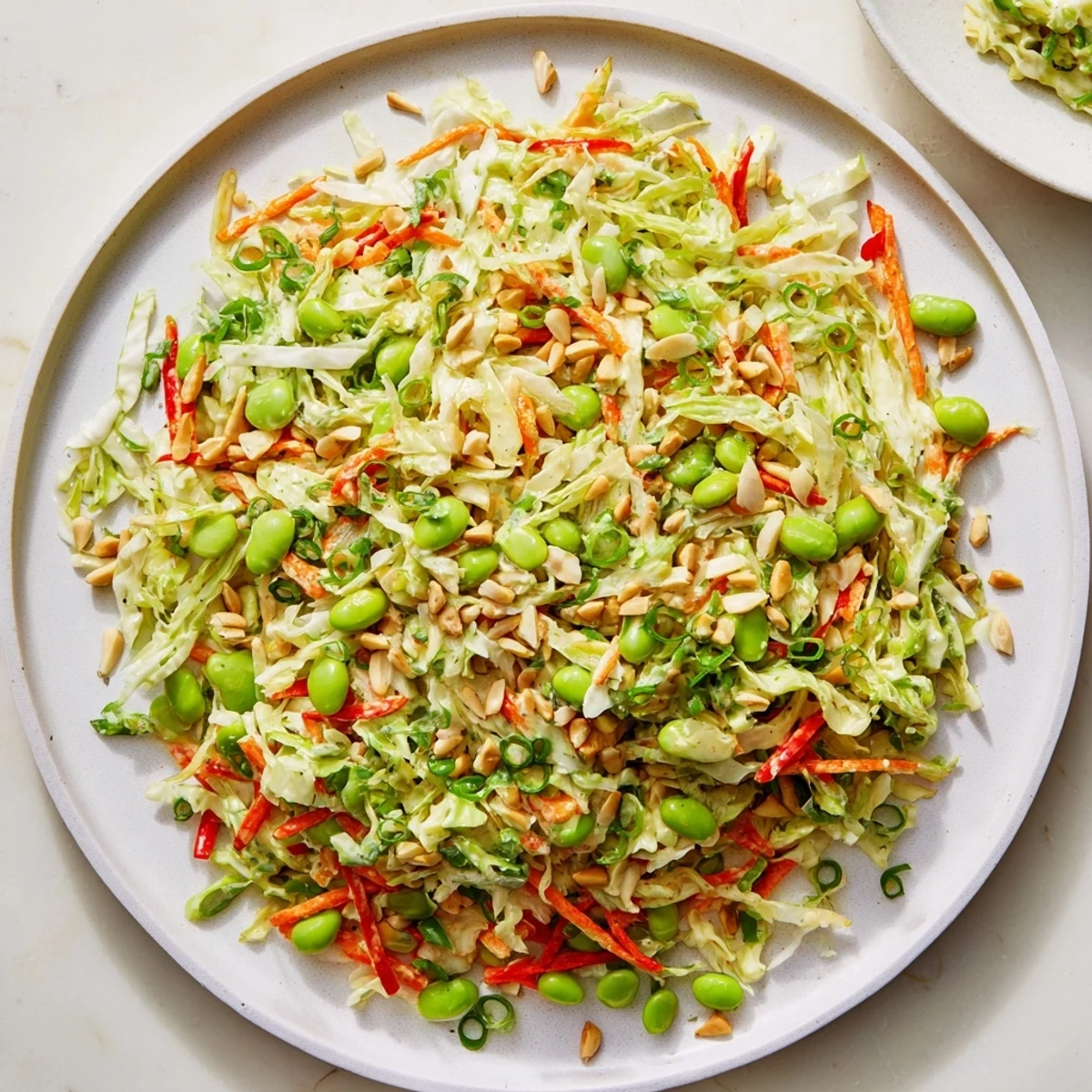 Fresh, colorful Crunchy Cabbage and Edamame Salad topped with toasted almonds, ready to be enjoyed.