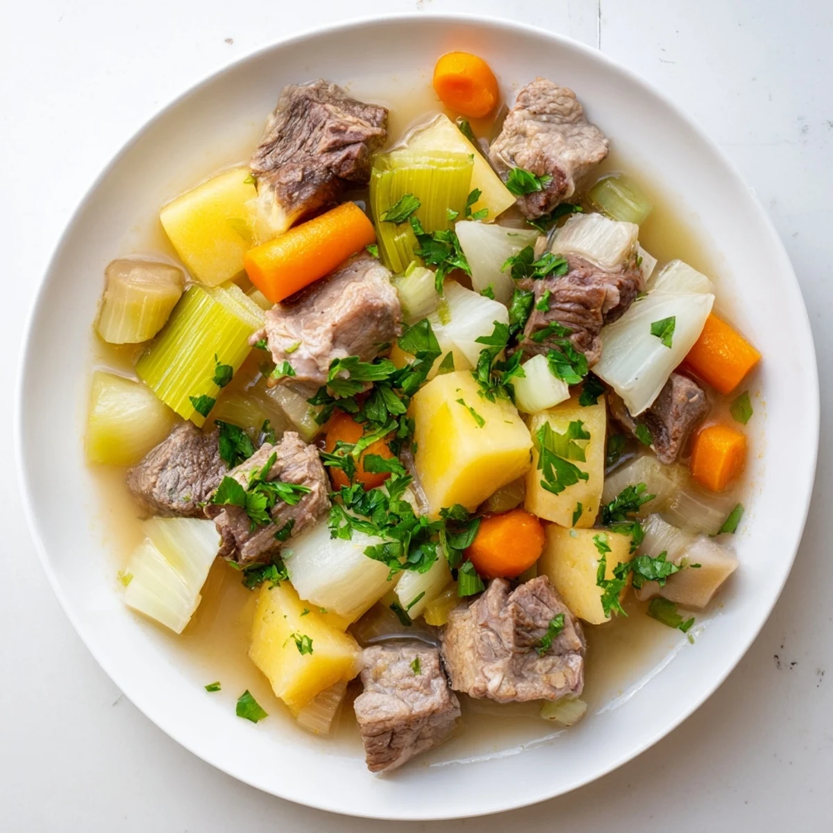Warm your kitchen with this delicious, rich Welsh Cawl stew, showcasing juicy lamb and savory flavors.