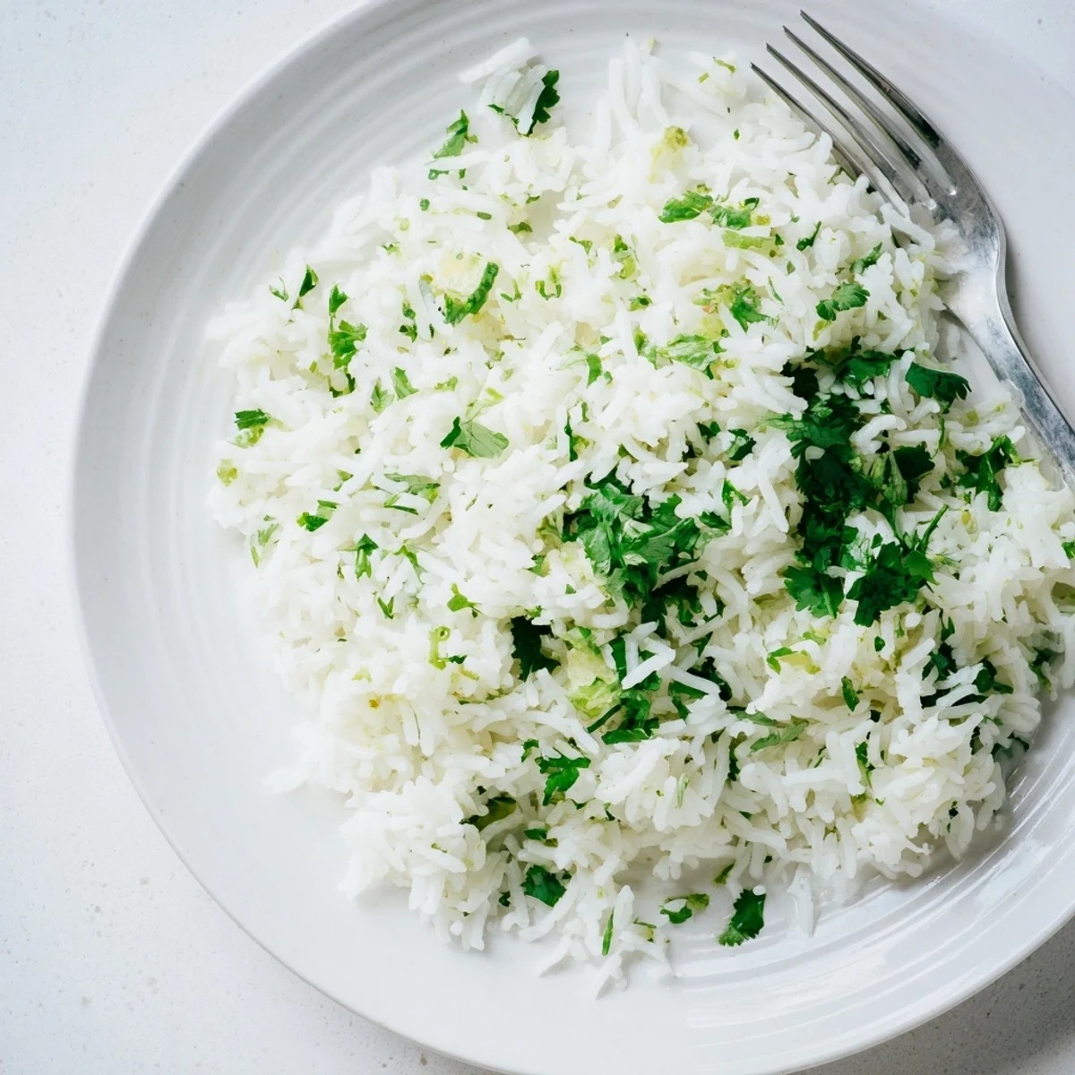 Fluffy, aromatic cilantro lime rice garnished with fresh cilantro, perfect as a vegan side for Mexican-inspired meals.