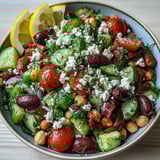 Freshly tossed Greek Bean Salad with Lemon Marinated Beans in a bowl, garnished with parsley and Kalamata olives.