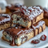 A close-up of chewy graduation cookie bars, decorated with vibrant candy-coated chocolates and glossy white chocolate drizzle.  