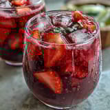 Refreshing Homemade Starbucks Strawberry Açaí Refresher with vibrant red strawberries and açaí powder in a chilled glass.