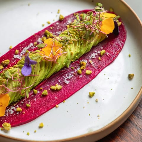 Beautiful, artistic plating of The Modernist Stripe with microgreens, garnishing a flavorful appetizer.
