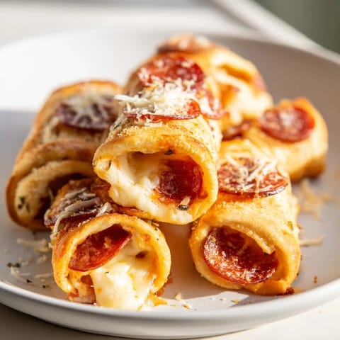 Close-up of crispy air fryer pizza rolls, perfect bite-sized snacks, served with dipping sauce.