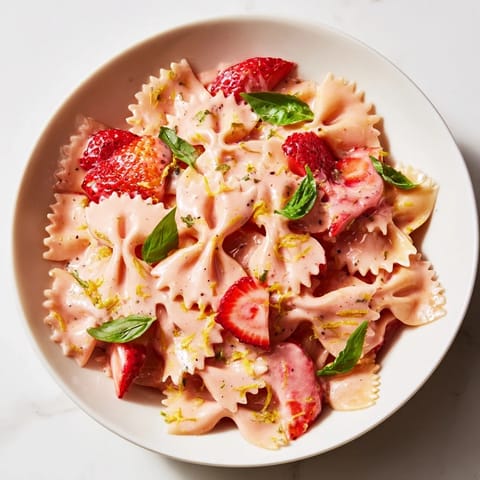 Pasta coated in a pink strawberry sour cream sauce, ready for a simple, refreshing lunch.