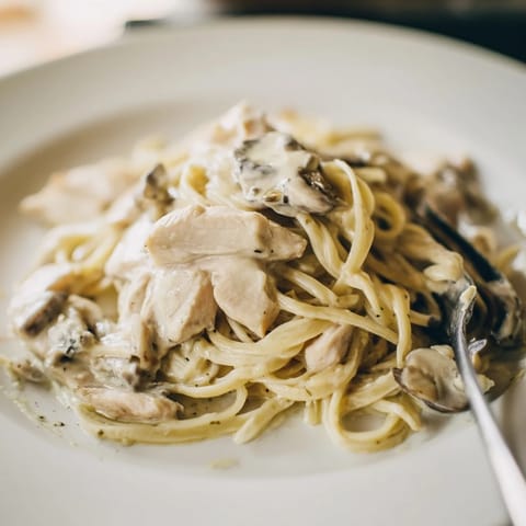 Creamy Mushroom Chicken Spaghettini features golden chicken strips and al dente pasta coated in a velvety mushroom cream sauce garnished with fresh parsley.