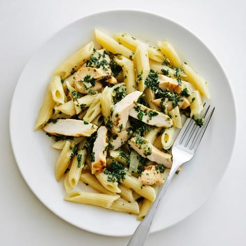 Succulent grilled chicken pieces rest atop al dente penne pasta, generously drizzled with a bright, garlicky chimichurri sauce.  