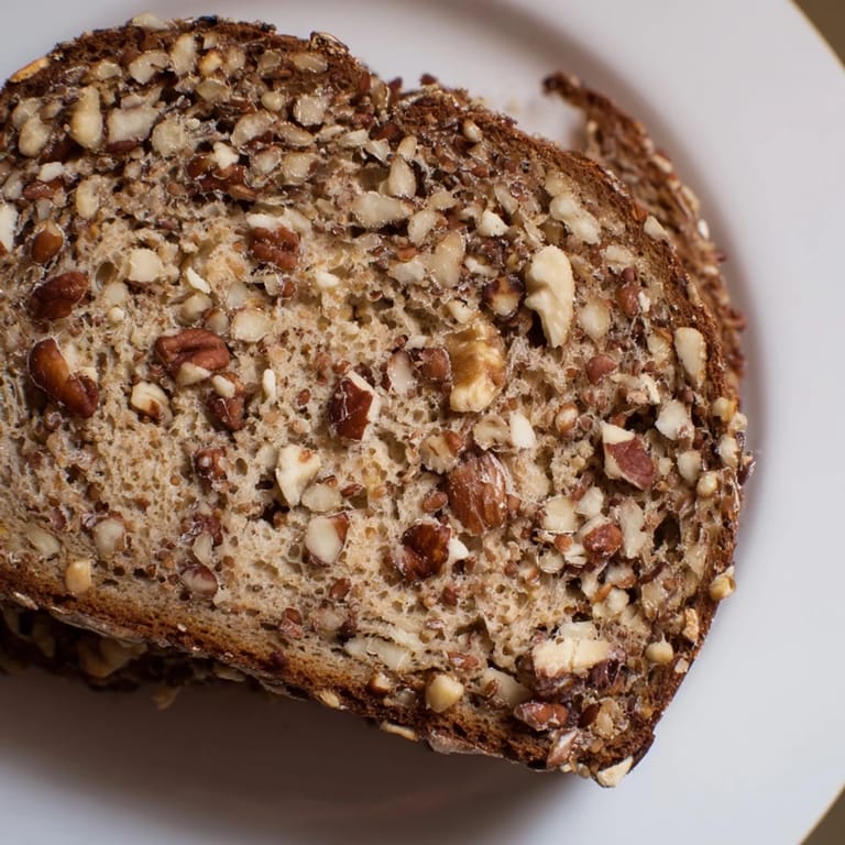 Warm, inviting image of a freshly baked nutty whole wheat loaf bread, with visible nut pieces.