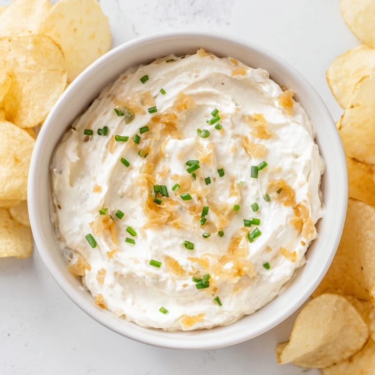 Close-up of potato chips and onion dip; the savory snack is ready and inviting guests.