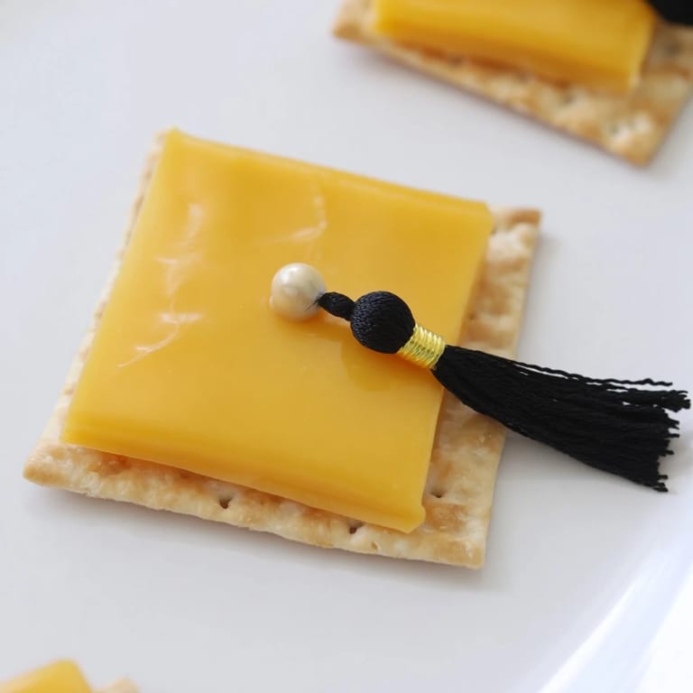 Close-up of adorable Graduation Cap Snacks, perfect party food with cheese and cracker foundations.