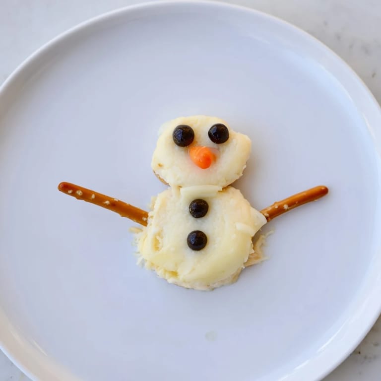Delicious Melted Snowman Cheese Bites, served with crackers, offer a fun, easy, and flavorful treat.