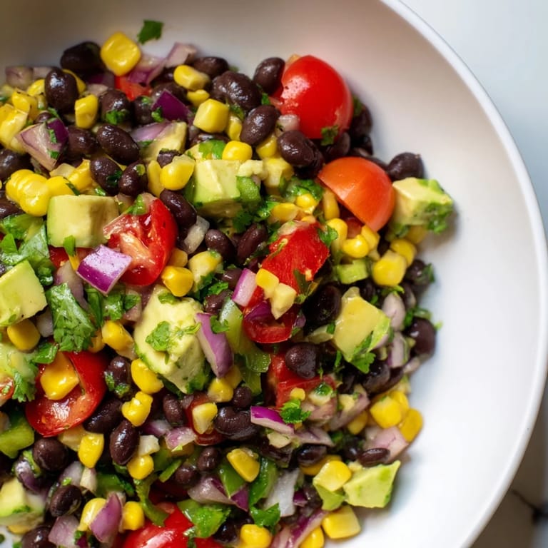 A refreshing bowl of Southwestern Black Bean and Corn Salad, drizzled with lime-cilantro dressing.