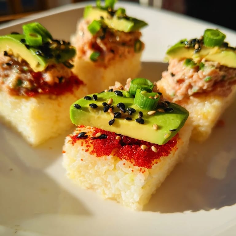 Savory Spicy Tuna Crispy Rice bites sitting on a white plate, offering crispy texture and spicy flavor.