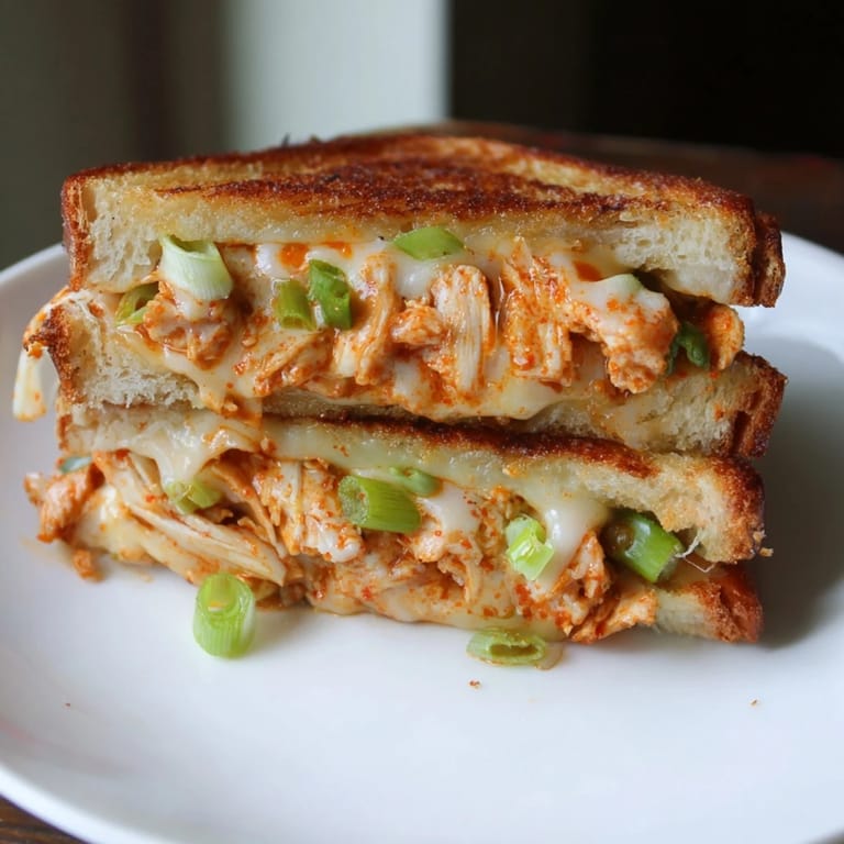 Freshly grilled Gochujang Mayo Chicken Sandwich, sliced and ready to eat with a Korean-inspired flavor.
