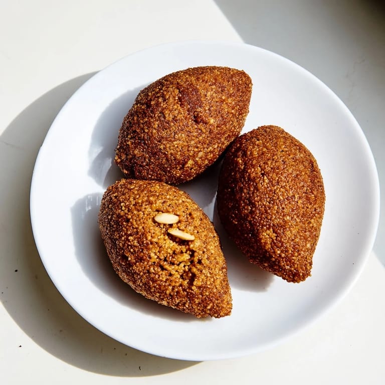 Close-up of baked Lebanese Kibbeh with a drizzle of olive oil, showcasing its delightful textures and flavors.