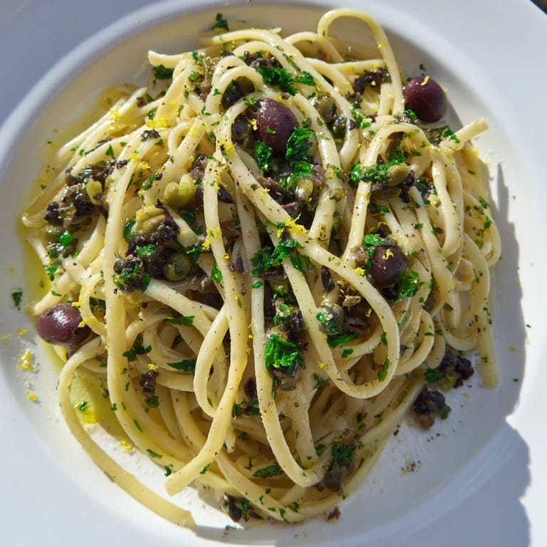 A warm skillet of olive tapenade pasta with al dente noodles and a chunky olive sauce, ready for a quick vegetarian dinner.