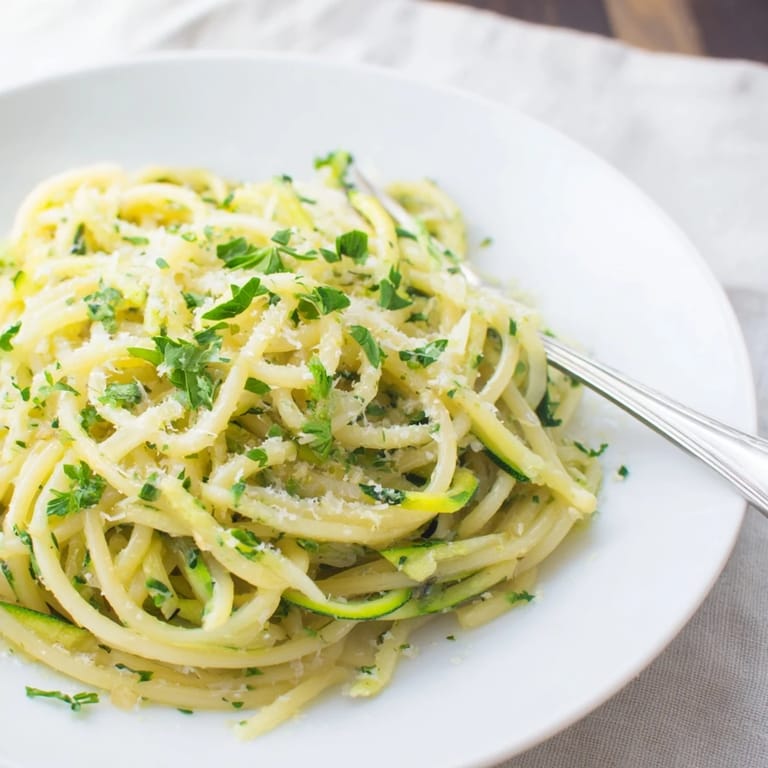 Savory garlic and melted butter swirl around tender zucchini noodles and pasta, finished with a sprinkle of grated Parmesan.