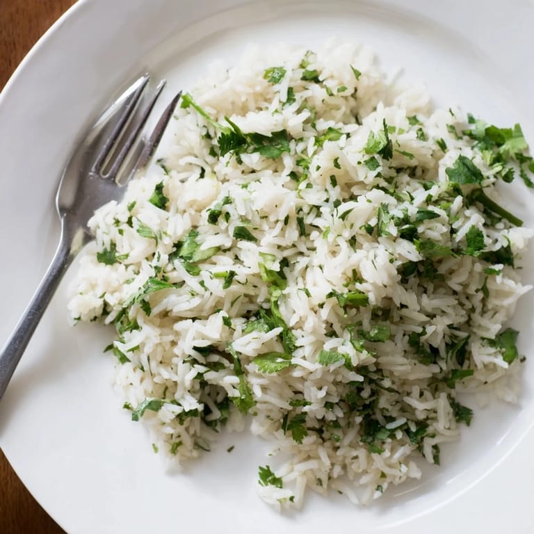 A close-up of fluffy cilantro lime rice with bright green herbs and zesty lime, ready to be served.