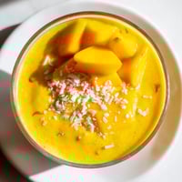 Golden-hued Mango Turmeric Smoothie, expertly blended with ginger, ready for chilled refreshment.