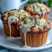 Freshly baked lemon poppy seed muffins with a glossy lemon glaze, perfect for spring brunch or an afternoon treat.